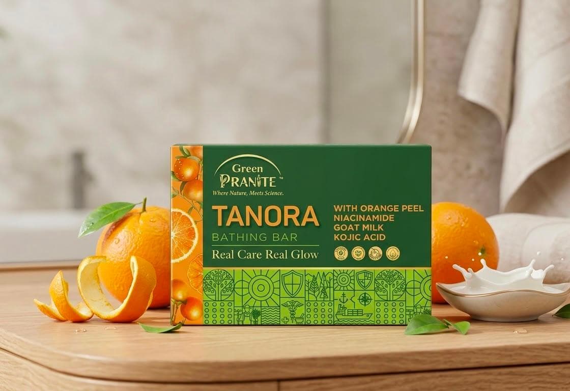 Green Pranite TANORA Bathing Bar on a wooden counter with fresh oranges, orange peel and goat milk.